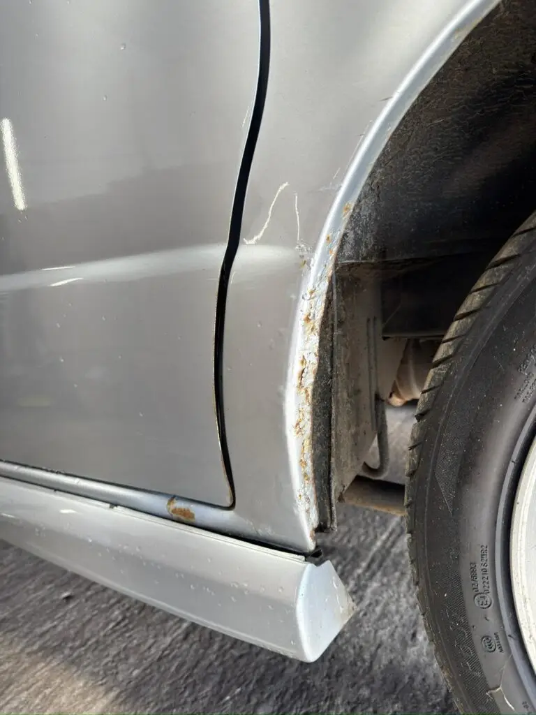 Close up of Mazda Bongo rear arch corrosion before restoration