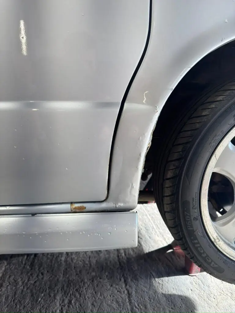 Close up of Mazda Bongo rear arch corrosion before restoration