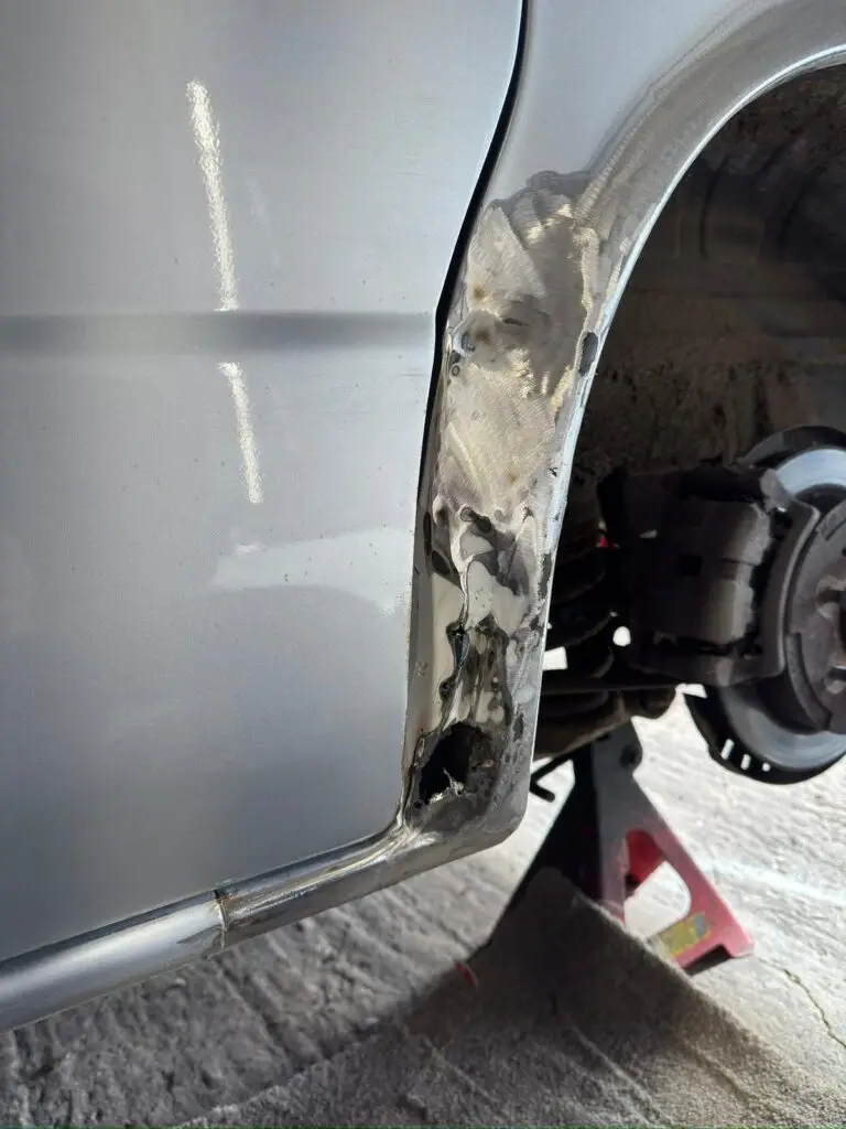 Close up of Mazda Bongo rear arch corrosion before restoration