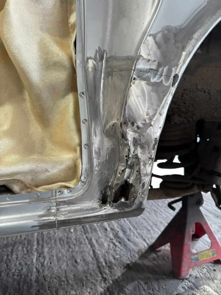 Close up of Mazda Bongo rear arch corrosion before restoration